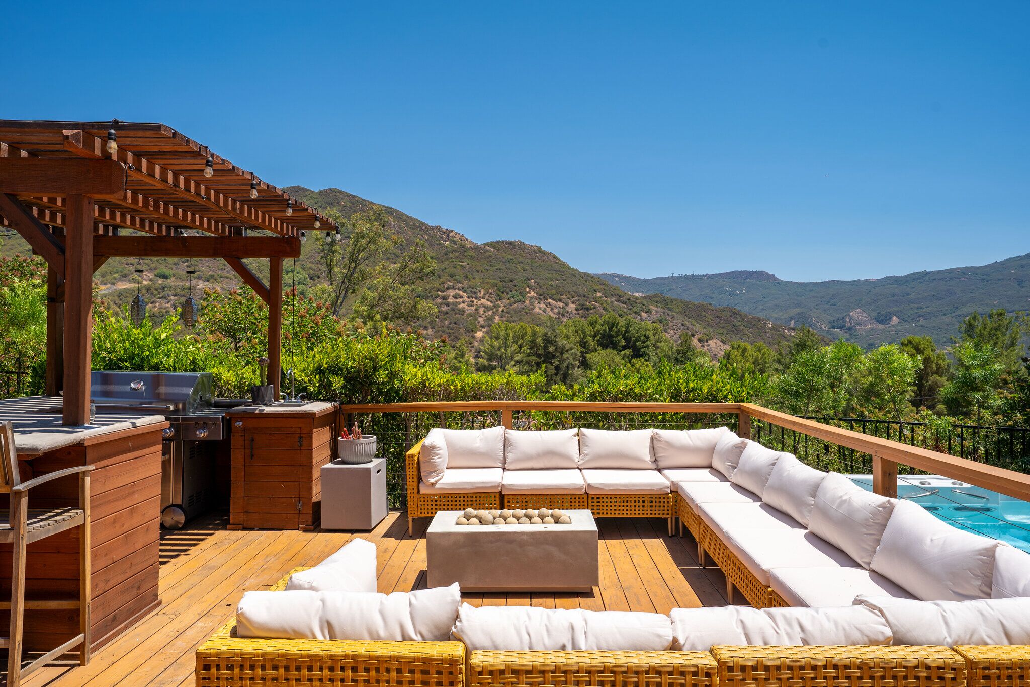 Wraparound sectional and pergola bar on the spa deck overlooking canyon ridgelines