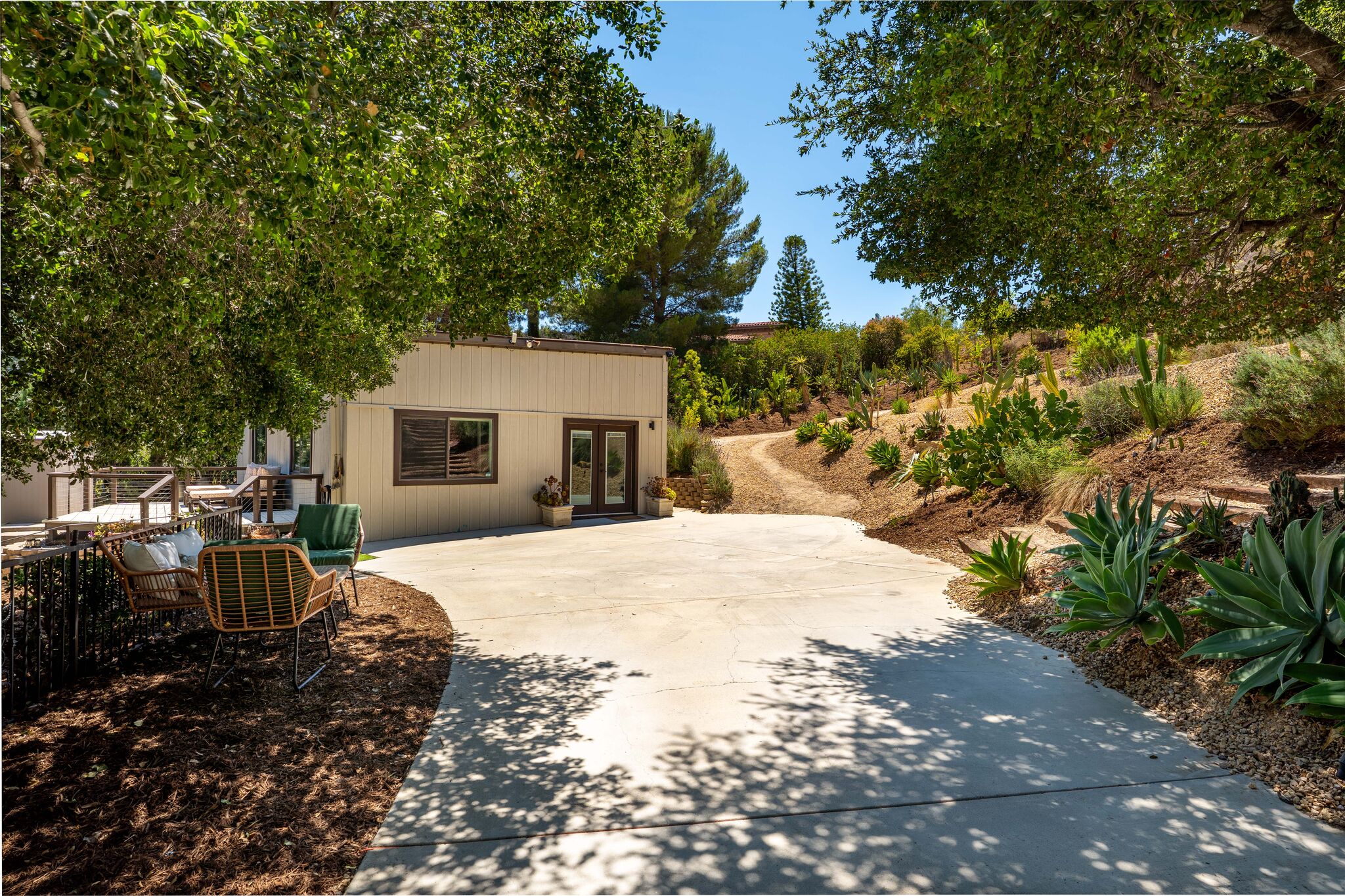 Garden path leading to the white studio among the trees